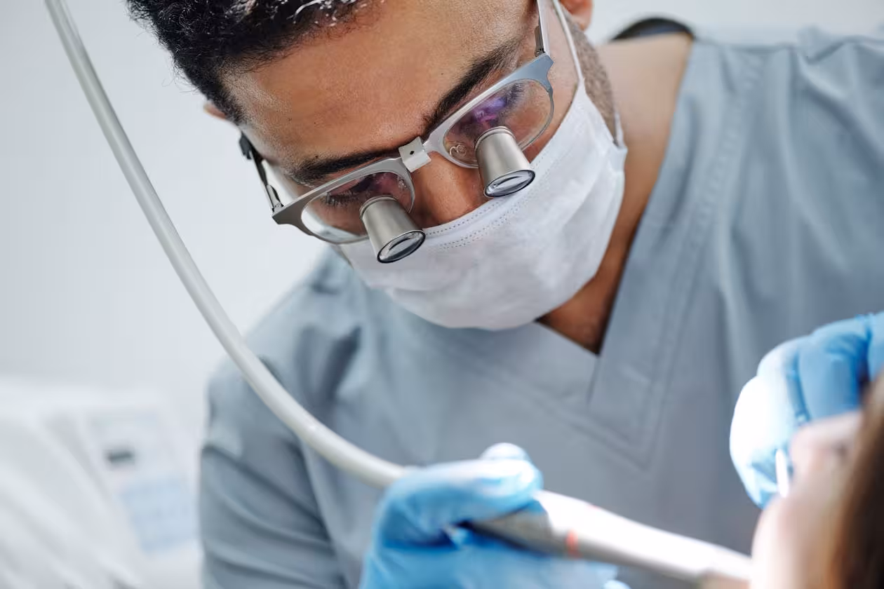 Endodontist wearing dental loupes for root canal retreatment