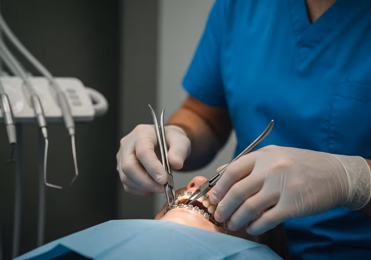 Orthodontist adjusting braces wire at Empire Dental Clinic